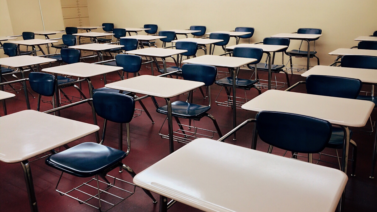 Image of beige and blue desks in a classroom. 