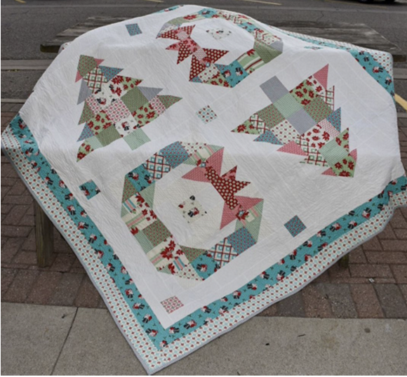 Lisa Jo Girodat  Looking for a layer cake or charm pack friendly quilt pattern? Check out EQ user, Lisa Jo's quilt, Trees & Wreaths! Get the free pattern on the Moda Fabrics website! 