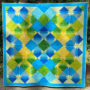 Brianna Roberts  Everyone is loving this beautiful quilt by EQ8 user, Brianna Roberts. She used a Kathy Brett Engle fabric line called Free To Fly. The fabric will be out this fall. Brianna says, “I designed this pattern to provide a pop of colors of blues, greens and yellows.“   We love it! See more of Brianna's work on her Instagram page, @briannaroberts71
