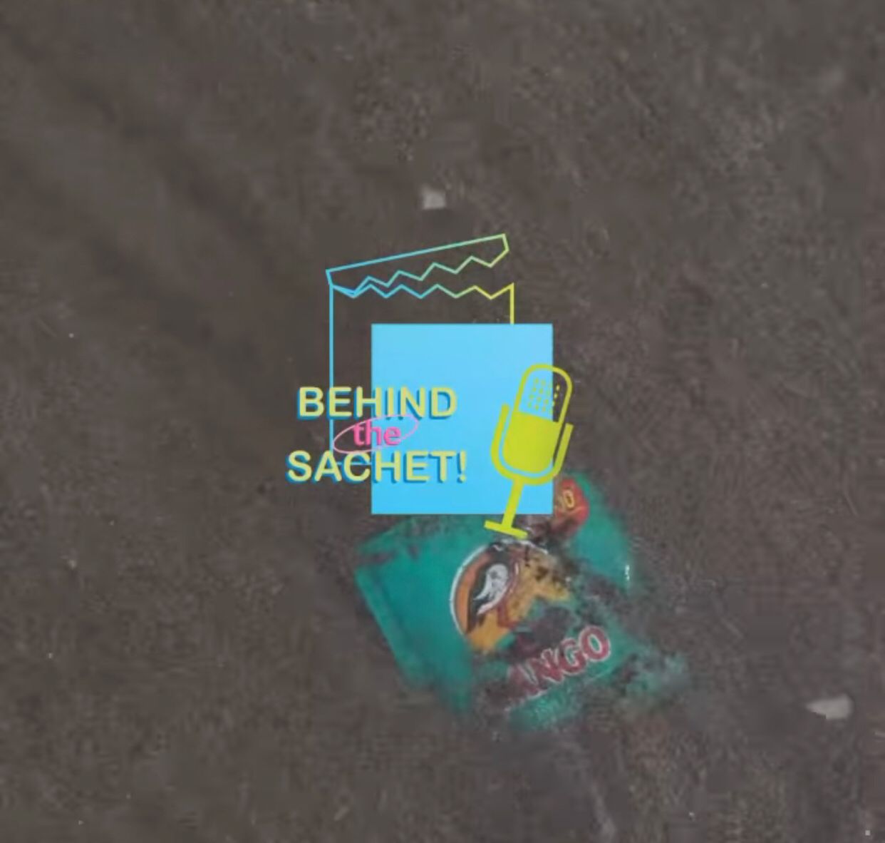 An image of a sachet sitting in sand under shallow water. In the foreground is the “Behind the Sachet!“ logo with a blue video icon and yellow microphone icon.