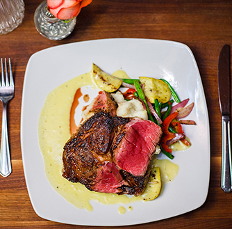 An entree of a steak dinner on a white plate.