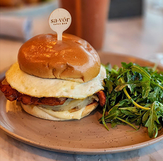An egg sandwich with a side of arugula salad. 